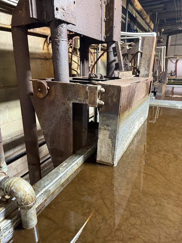 Front view of the machine, with the structural frame standing above the surface of the cleaning bath.