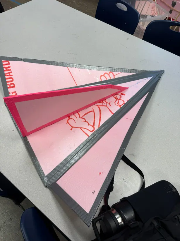 The glider prototype seen from above at an angle, showing the delta wing panels and reinforced edges.