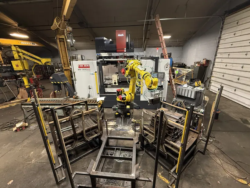 FANUC R-1000iA/100F robot and Yama Seiki BM-1600MAX vertical machining center in the automated track shoe cell.